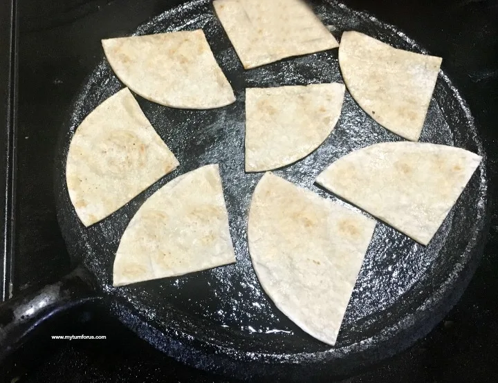 Tortillas on a comal for green enchilada casserole