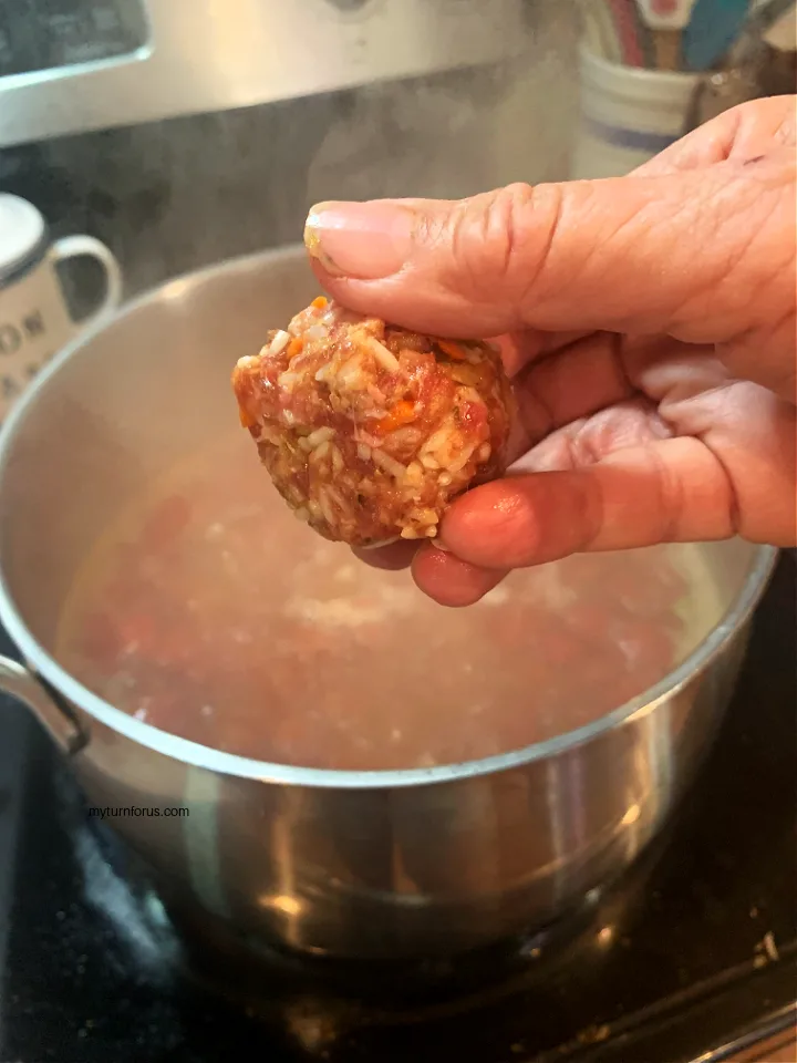 dropping mexican meatballs into broth