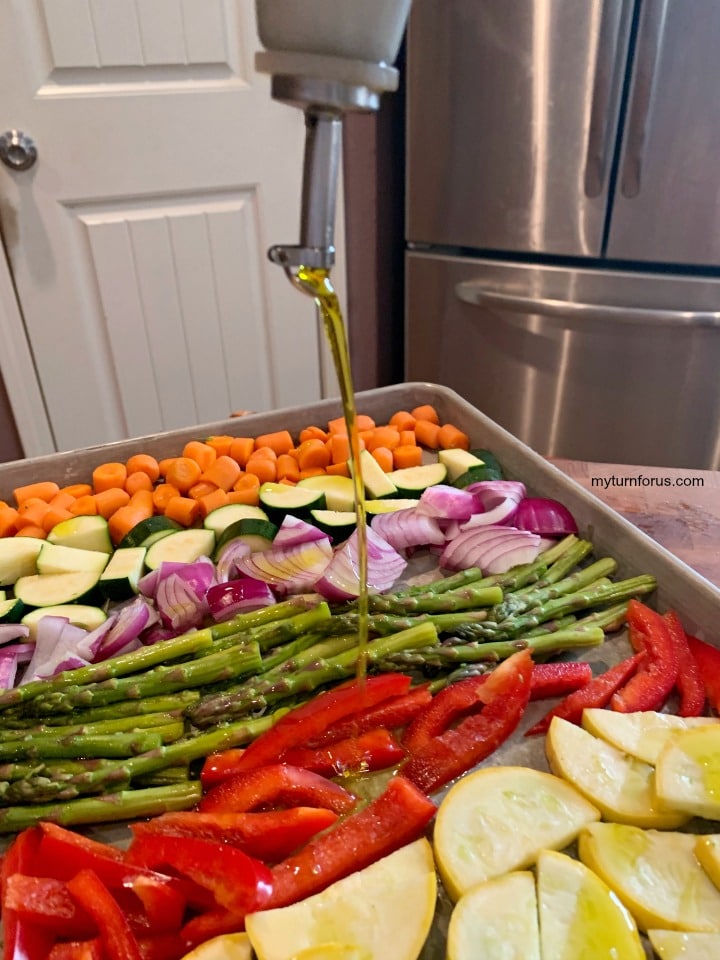 drizzling olive oil on roasted vegetables, rainbow vegetable tray
