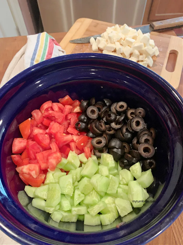 cucumbers, tomatoes and olives in a blue bowl