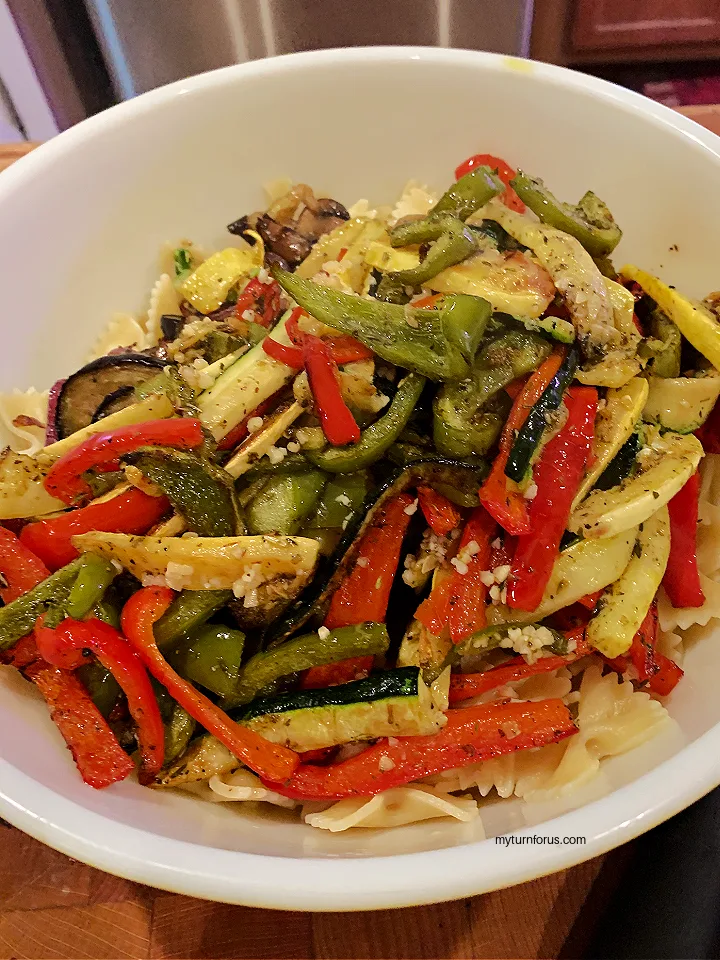 adding the roasted vegetables to the farfalle pasta