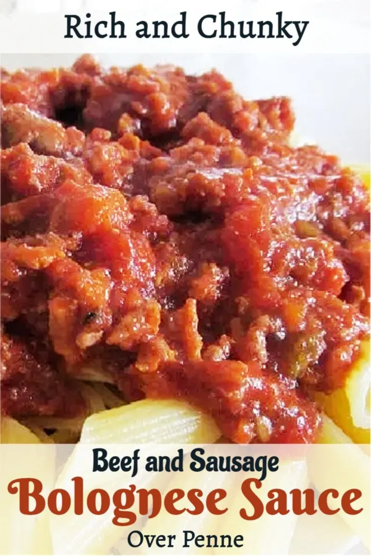 A chunky beef and sausage bolognese sauce is cooked in a dutch oven and served over penne pasta. 