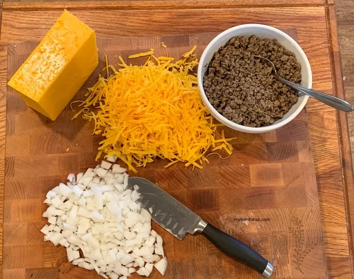 stacked enchiladas, ingredients for stacked enchiladas, grated cheese, cooked ground beef and chopped onions