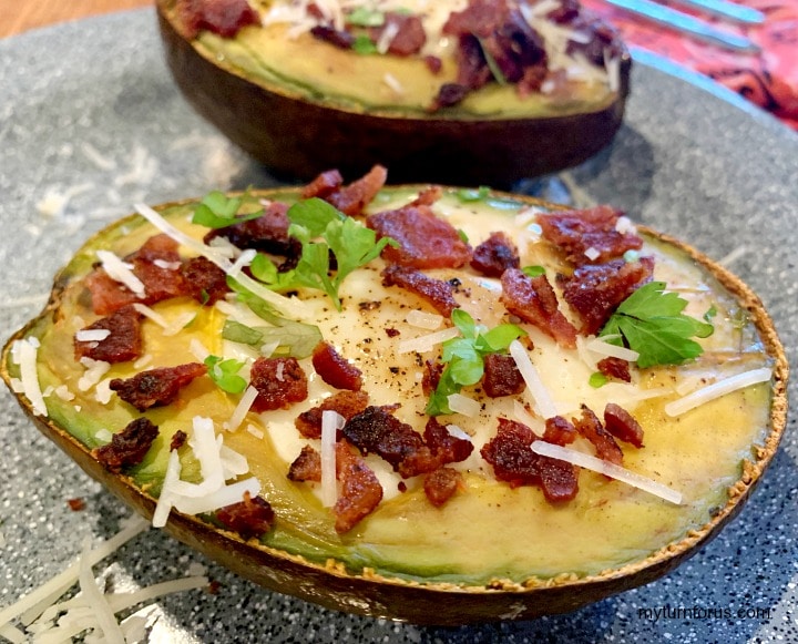 baked avocado with egg and topped with peppered bacon pieces, avocado egg cups