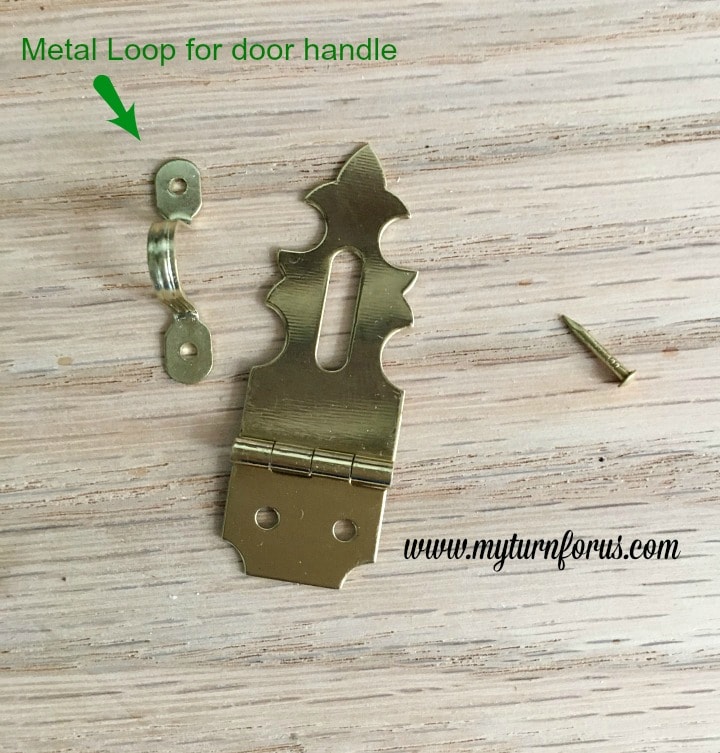 Horseshoe Fairy Door for the most magical fairy garden! https://www.myturnforus.com/2016/03/horseshoe-fairy-door.html Decorative brass hasp beside the small metal loop used as the fairy door handle, with an arrow identifying the loop.