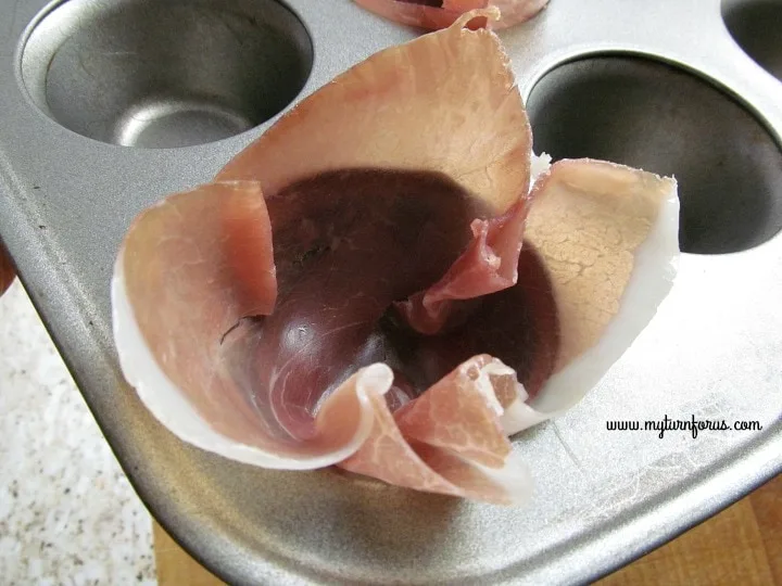 placing prosciutto into muffin tin 