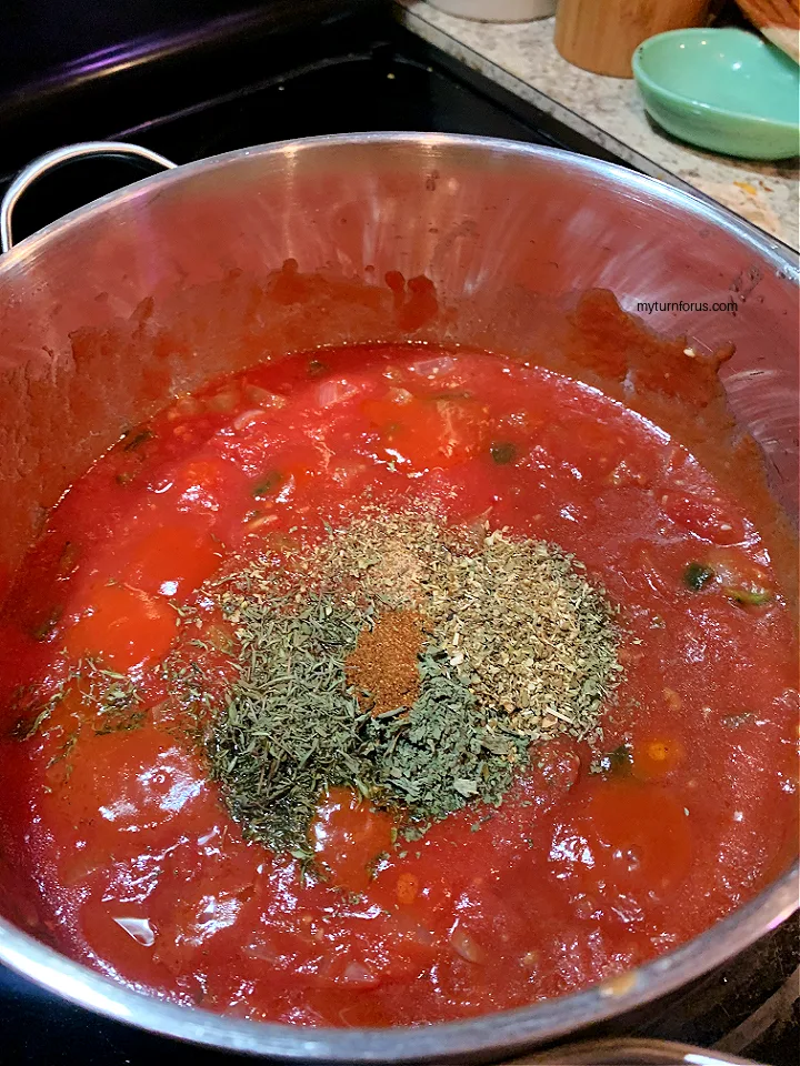 adding spices to creole chicken sauce