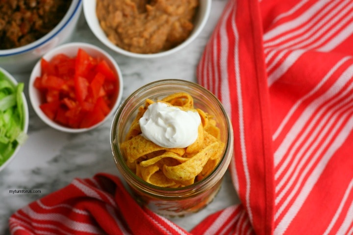 adding chips and sour cream to jar
