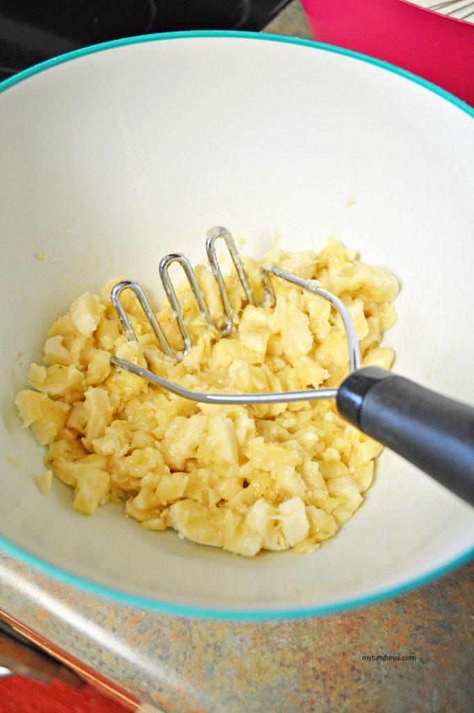 Ripe bananas being mashed in a mixing bowl for banana bread with rum.