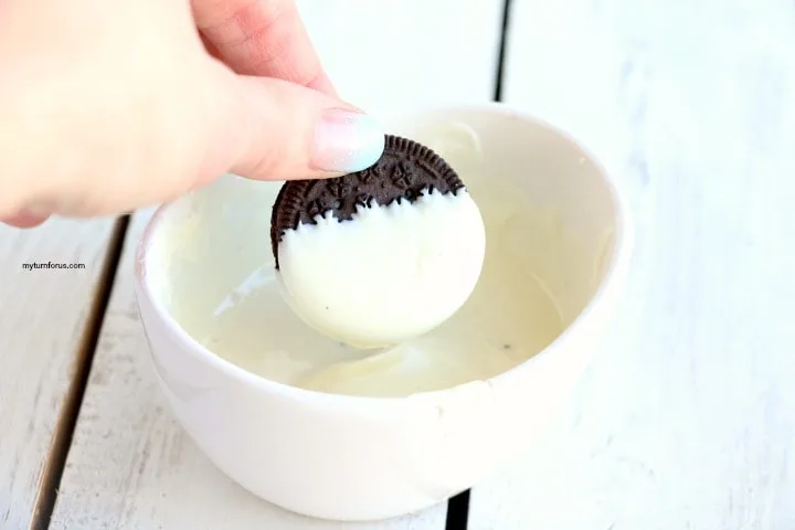 dipping the cookie into white chocolate