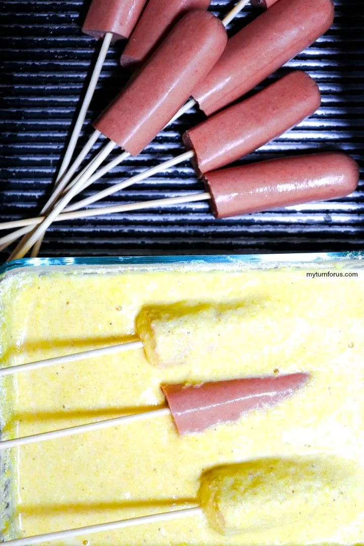 dipping hot dogs into the batter mix