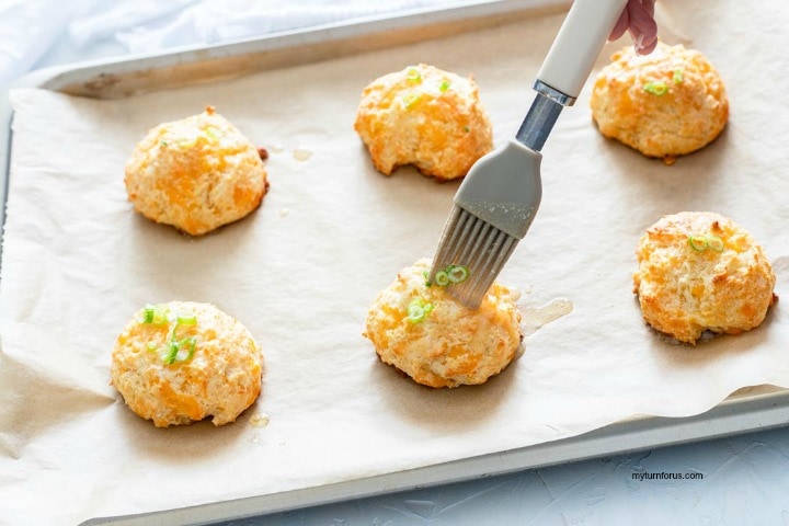 Brushing the cheddar biscuits with garlic butter