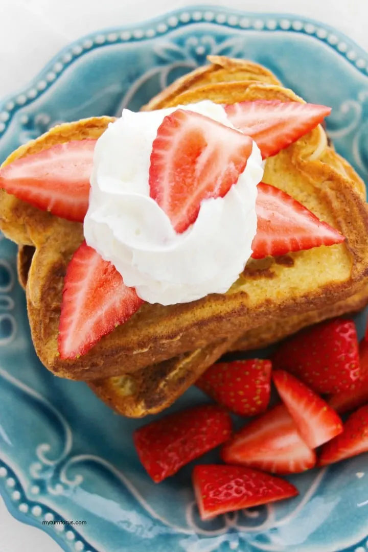 strawberries and whipped cream on cinnamon french toast