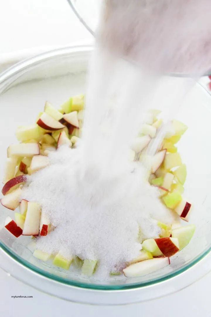 Pour sugar onto apple chunks