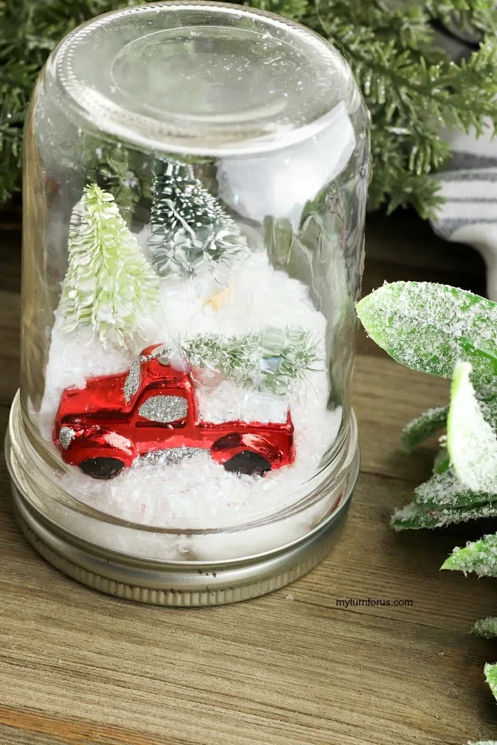 snow globe with red truck in a mason jar