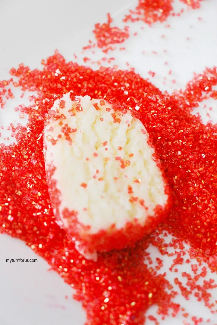 coating the red glitter cookies with glitter