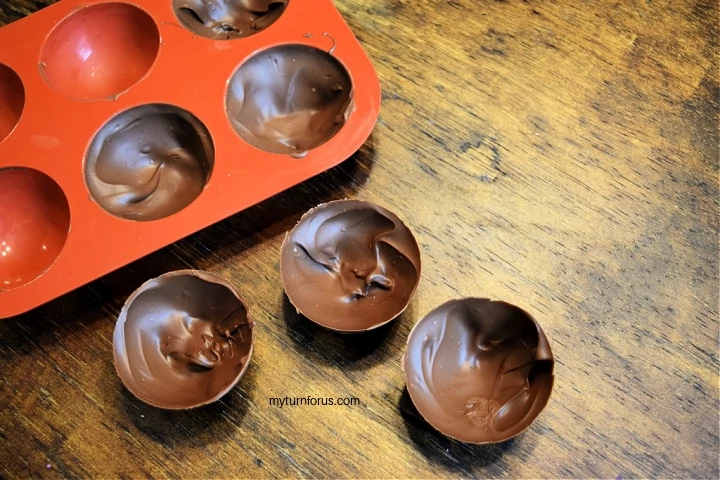 spooning chocolate into molds 