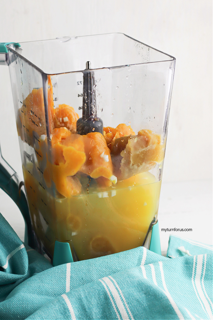 Adding orange and pineapple juice in a blender