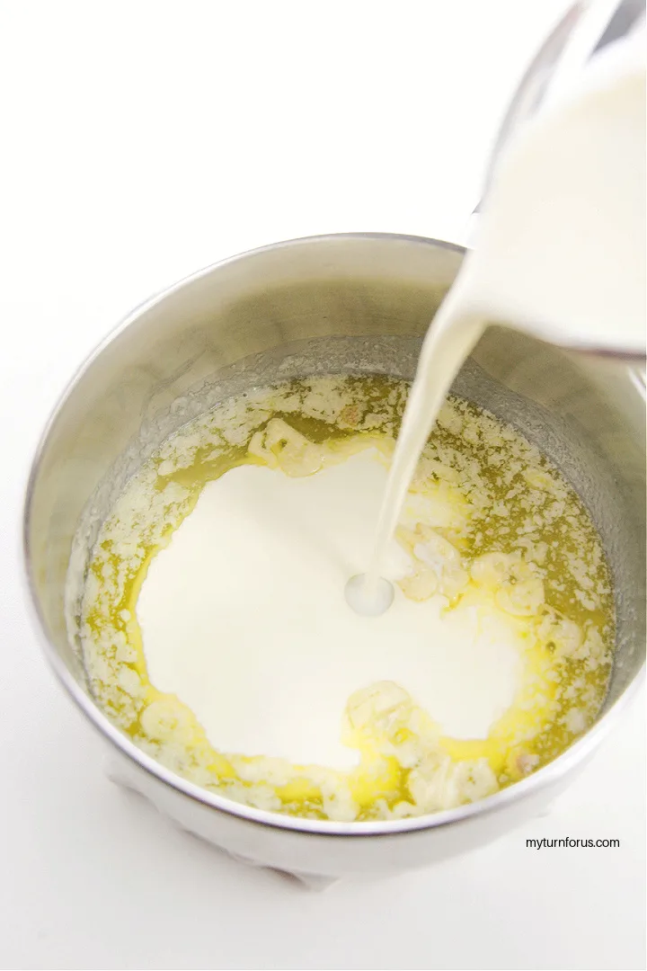 pouring milk into garlic butter