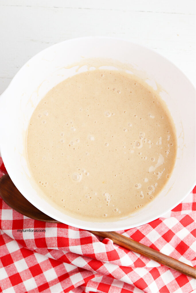 Spice cake batter mixed in a white bowl for caramel apple upside down Bundt cake.