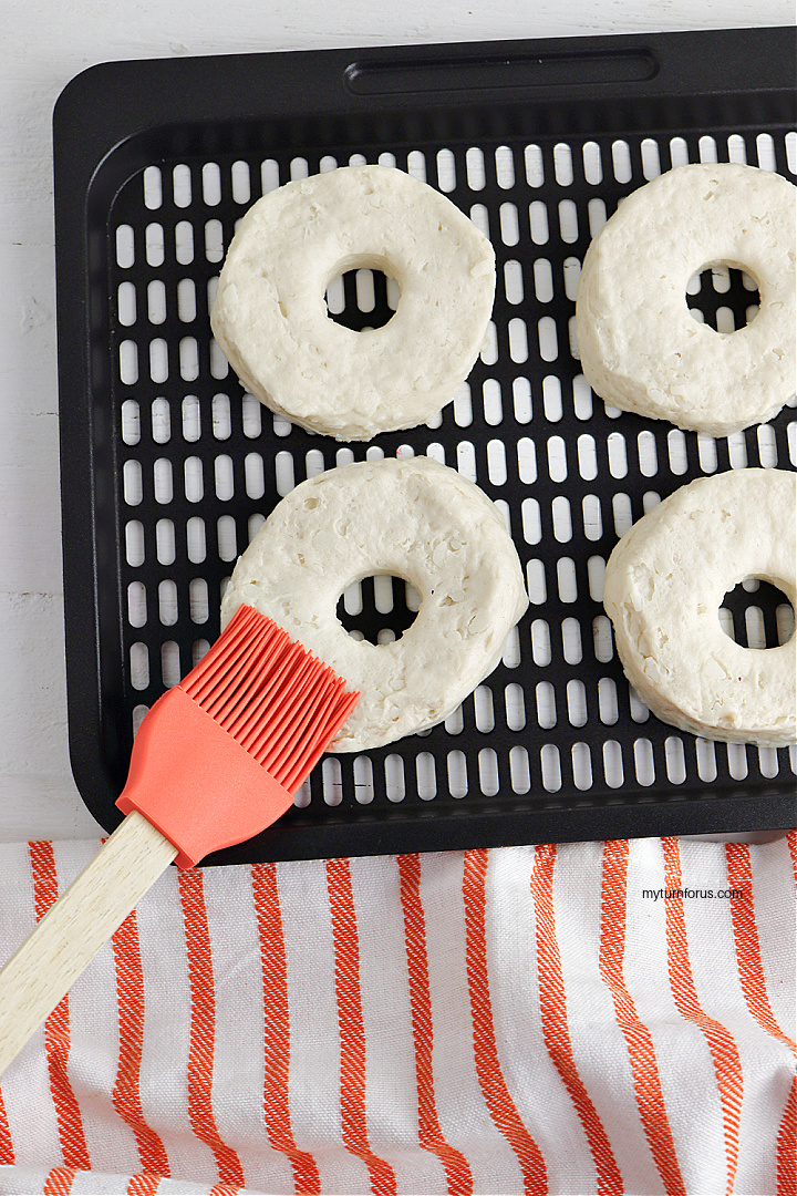 brushing butter on biscuit donuts
