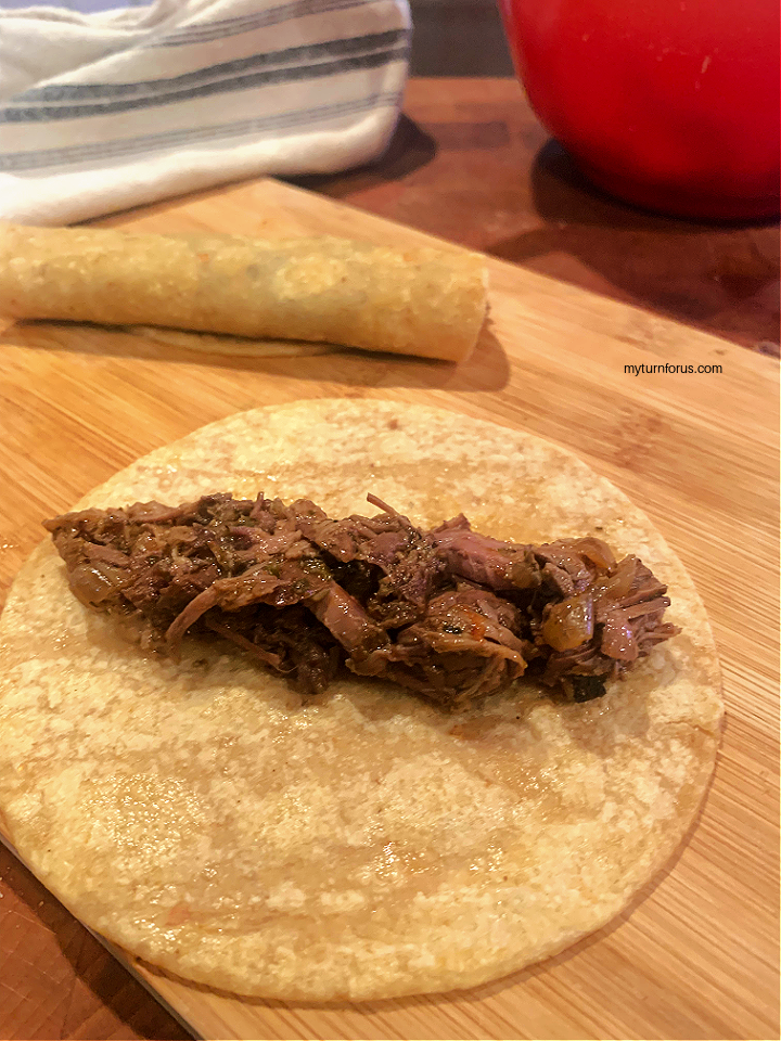 making a shredded beef taquito