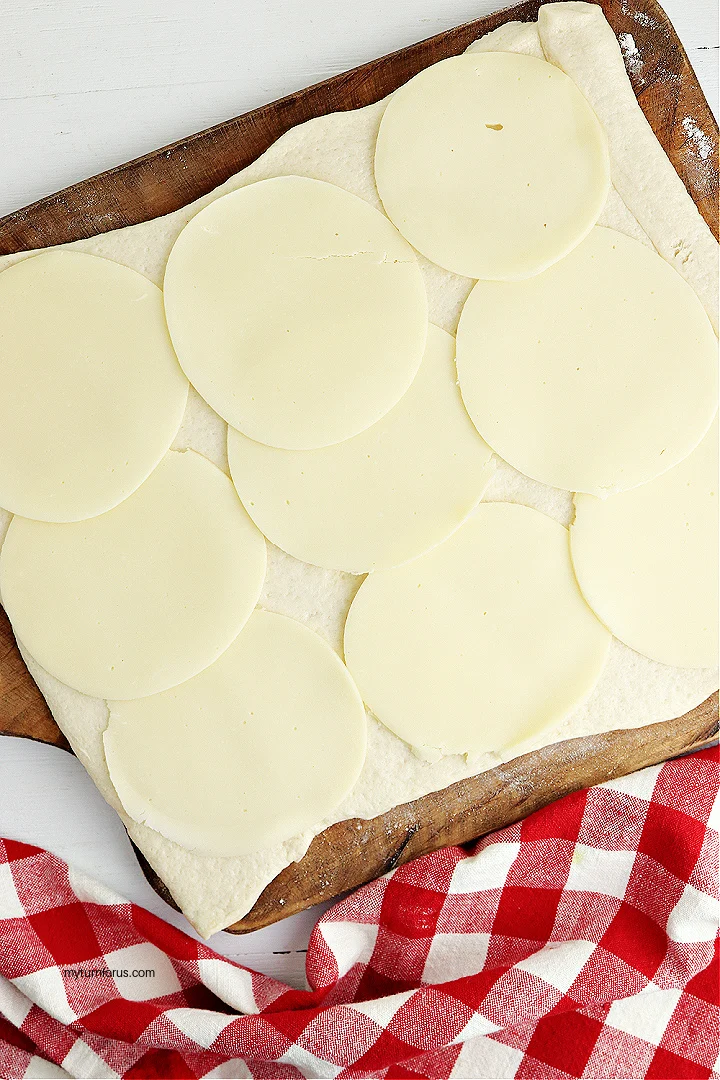 slices of cheese on pizza dough