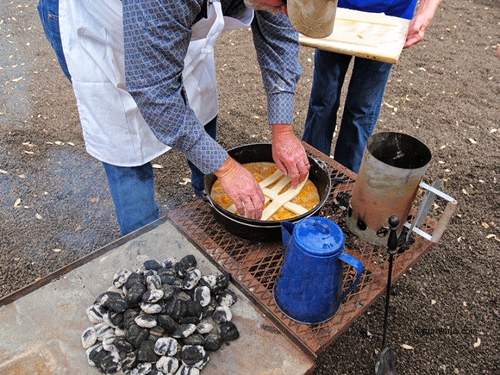 Dutch Oven Camping Recipes Preparing a Texas Peach Cobbler over the coals